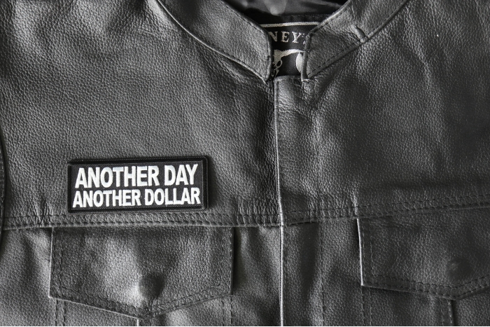 Another Day Another Dollar Patch - 4x1.5 inch - Embroidered Iron on Patch shown on leather vest