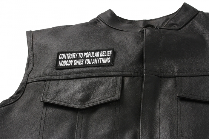Contrary to Popular Belief Nobody Owes You Anything Patch - 4x1.5 inch. Embroidered Iron on Patch shown on leather vest
