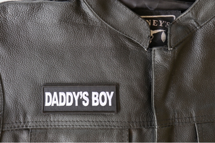 Daddy's Boy Patch - 4x1.5 inch - Embroidered Iron on Patch shown on leather vest