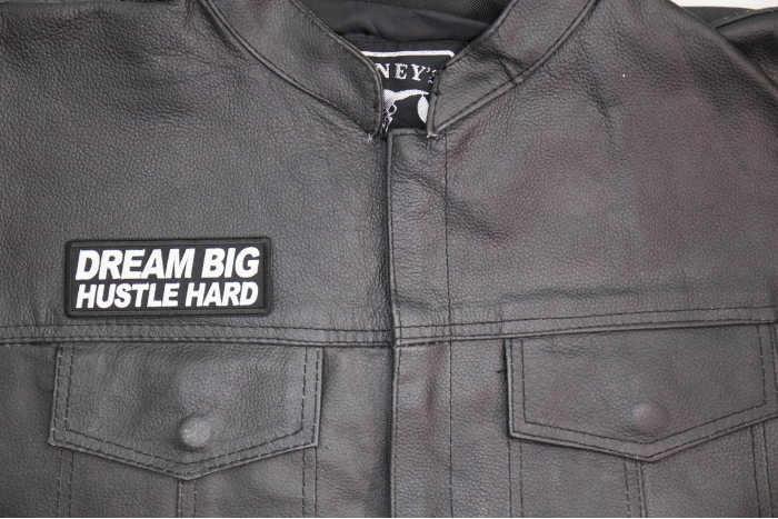 Dream Big Hustle Hard Patch shown on leather vest