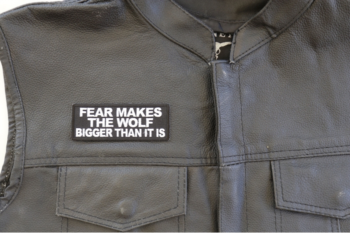 Fear Makes The Wolf Bigger Than it is Patch - 4x1.5 inch. Embroidered Iron on Patch shown on leather vest
