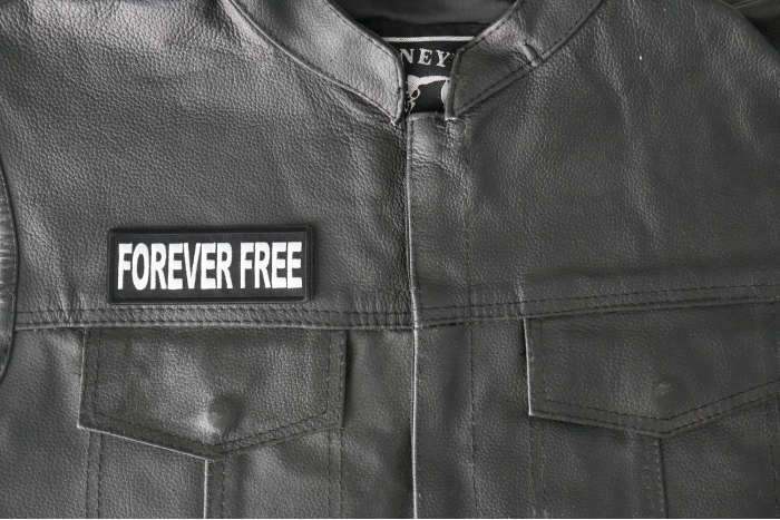 Forever Free Patch - 4x1.5 inch - Embroidered Iron on Patch shown on leather vest