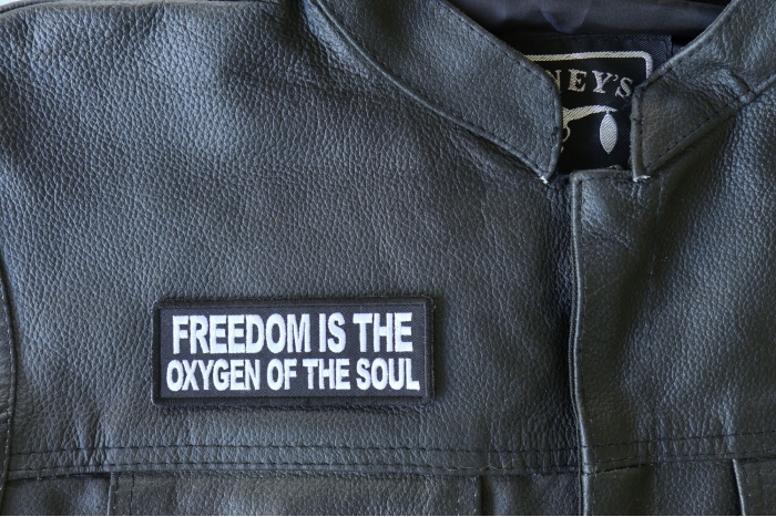Freedom is the Oxygen of the Soul Patch - 4x1.5 inch - Embroidered Iron on Patch shown on leather vest