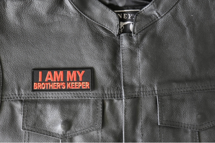 I am My Brother's Keeper Orange Patch - 4x1.5 inch - Embroidered Iron on Patch shown on leather vest