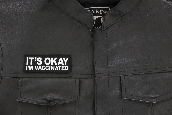 It's Okay I'm Vaccinated Patch - 4x1.5 inch - Embroidered Iron on Patch shown on leather vest