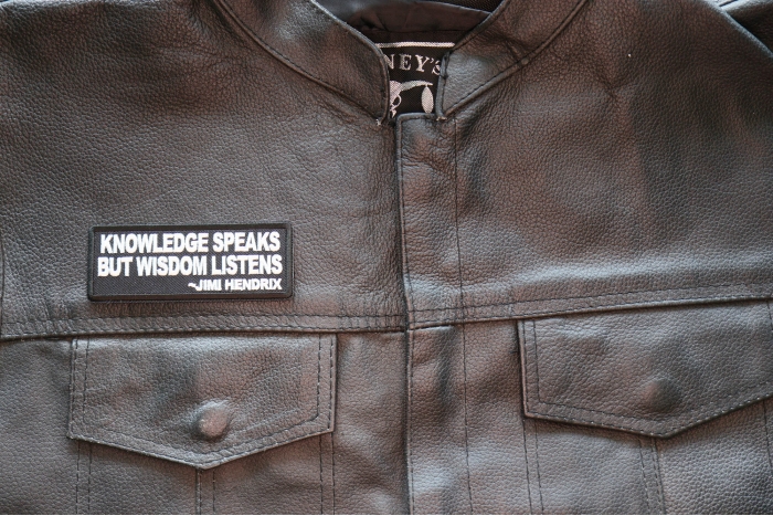 Knowledge Speaks But Wisdom Listens Patch shown on leather vest