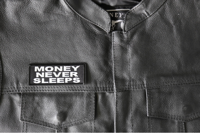 Money Never Sleeps Patch - 4x1.5 inch - Embroidered Iron on Patch shown on leather vest