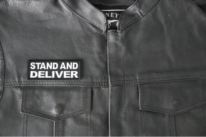 Stand and Deliver Patch - 4x1.5 inch - Embroidered Iron on Patch shown on leather vest