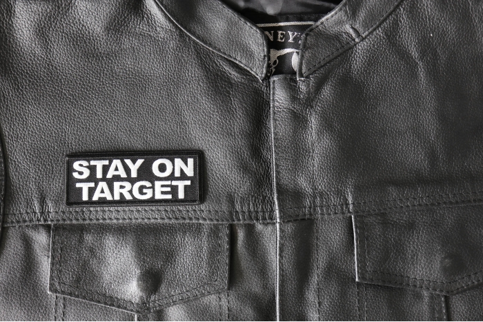 Stay on Target Patch - 4x1.5 inch - Embroidered Iron on Patch shown on leather vest