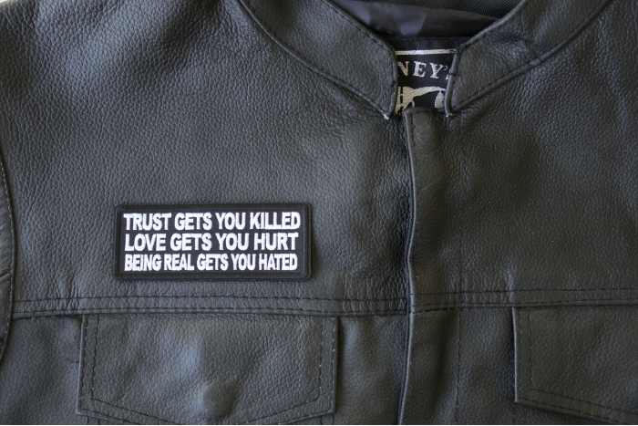 Trust Gets You Killed Love Gets you Hurt Being Real gets you Hated Patch - 4x1.5 inch - Embroidered Iron on Patch shown on leather vest