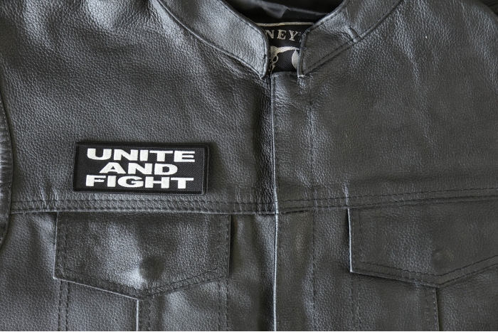 Unite and Fight Patch - 4x1.5 inch - Embroidered Iron on Patch shown on leather vest