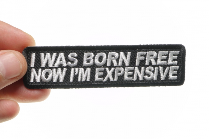 I Was Born Free Now I'm Expensive Patch shown on hand for size comparison