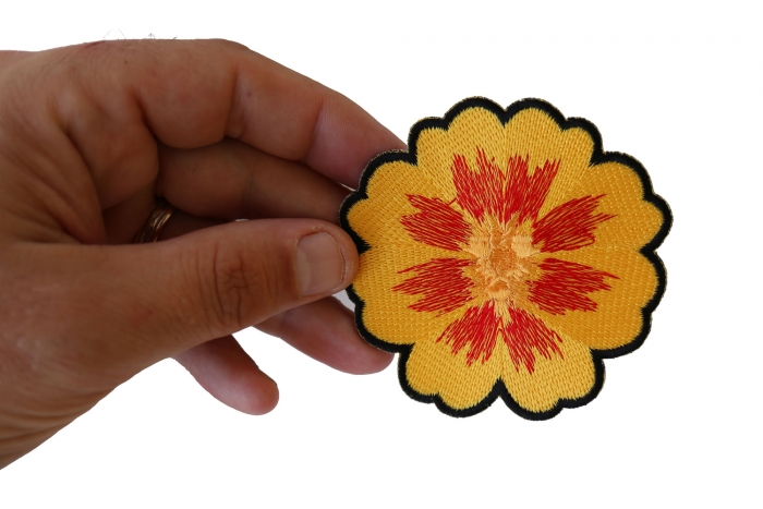 Orange Yellow Flower Iron on Patch shown on hand for size comparison