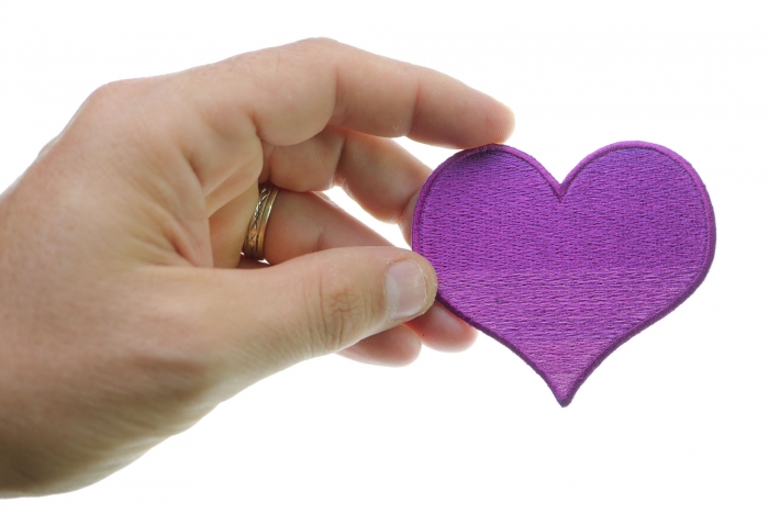 Pink Heart Iron on Patch shown on hand for size comparison