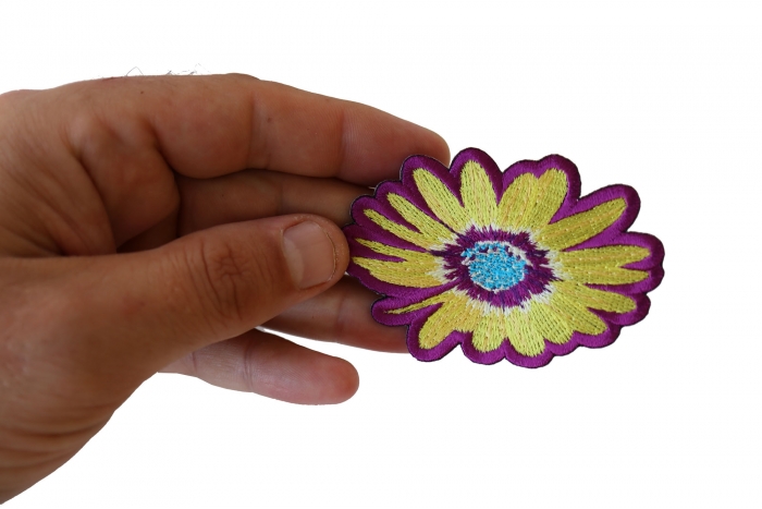 Yellow and Purple Flower Iron on Patch shown on hand for size comparison