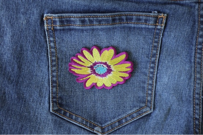Yellow and Purple Flower Iron on Patch shown on jeans