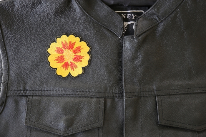 Orange Yellow Flower Patch - 3x3 inch. Embroidered Iron on Patch shown on leather vest