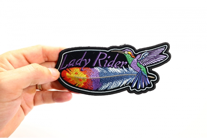 Hummingbird Lady Rider Feather Small Iron on Biker Patch shown on hand for size comparison