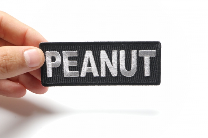 Peanut Funny Iron on Patch shown on hand for size comparison
