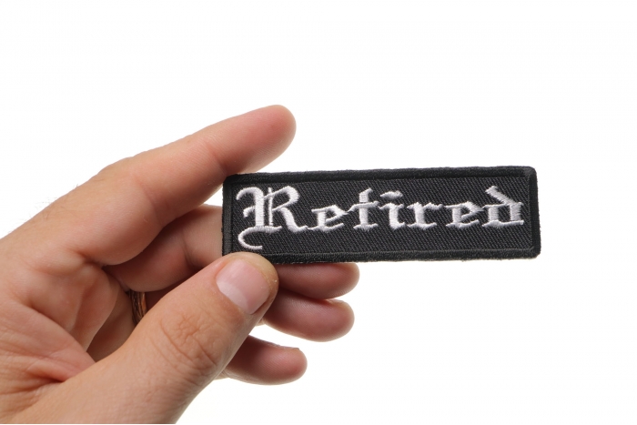 Retired Patch In Old English shown on hand for size comparison