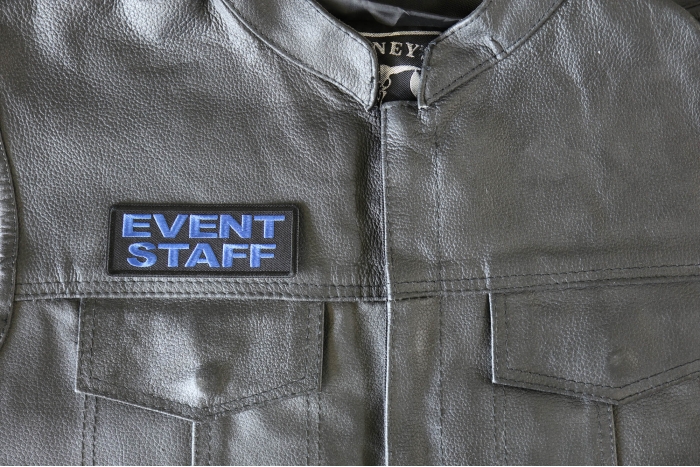 Event Staff Patch Blue - 4x1.5 inch - Embroidered Iron on Patch shown on leather vest