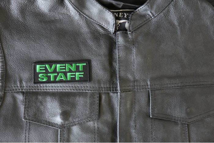 Event Staff Patch Green - 4x1.5 inch - Embroidered Iron on Patch shown on leather vest