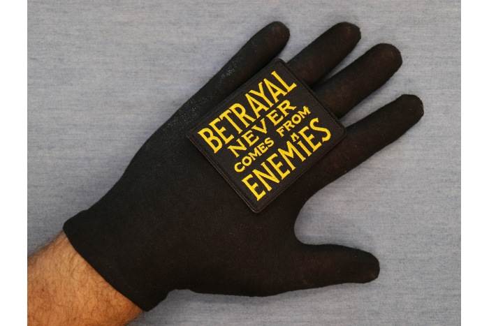 Betrayal Never Comes From Enemies Patch shown on hand for size comparison