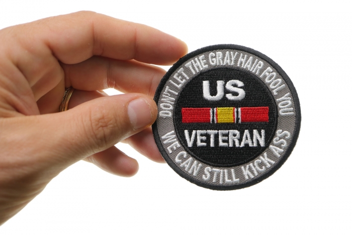 Don't Let The Gray Hair Fool You Patch In White Text shown on hand for size comparison