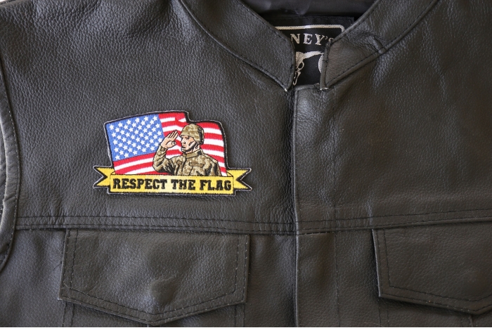 Respect The Flag Soldier Salute Patch - 4.5x2.4 inch. Embroidered Iron on Patch shown on leather vest
