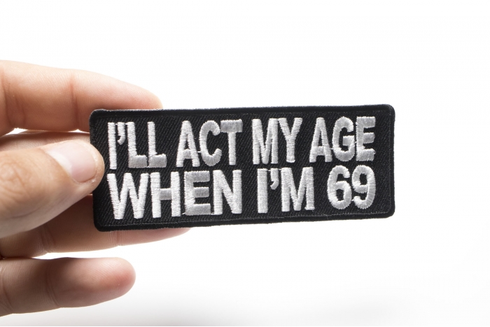 I'll Act My Age When I'm 69 Funny Naughty Iron on Patch shown on hand for size comparison