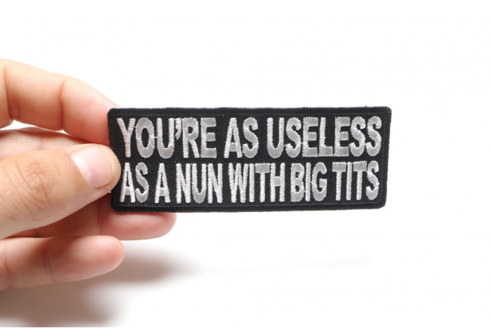 Your As Useless As A Nun With Big Tits Funny Naughty Patch shown on hand for size comparison