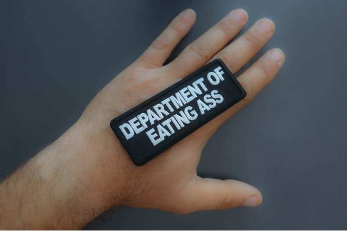 Department of Eating Ass Patch shown on hand for size comparison