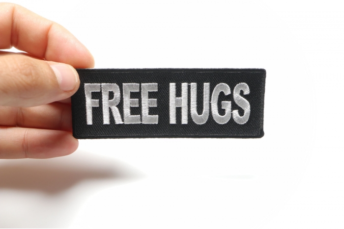 Free Hugs Naughty Iron on Patch shown on hand for size comparison