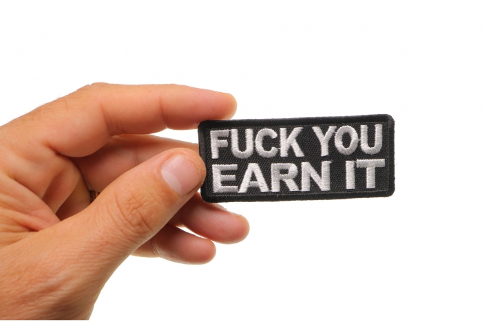 Fuck You Earn It Offensive Iron on Patch shown on hand for size comparison