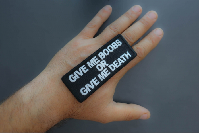 Give me Boobs or Give me Death Patch shown on hand for size comparison