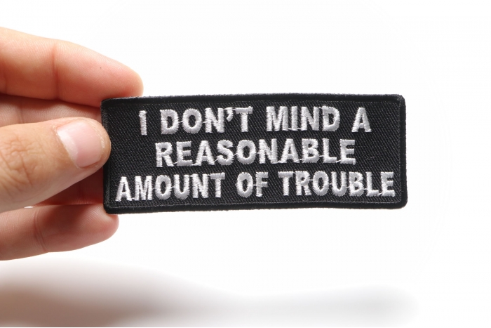 I Don't Mind A Reasonable Amount Of Trouble Naughty Iron on Patch shown on hand for size comparison