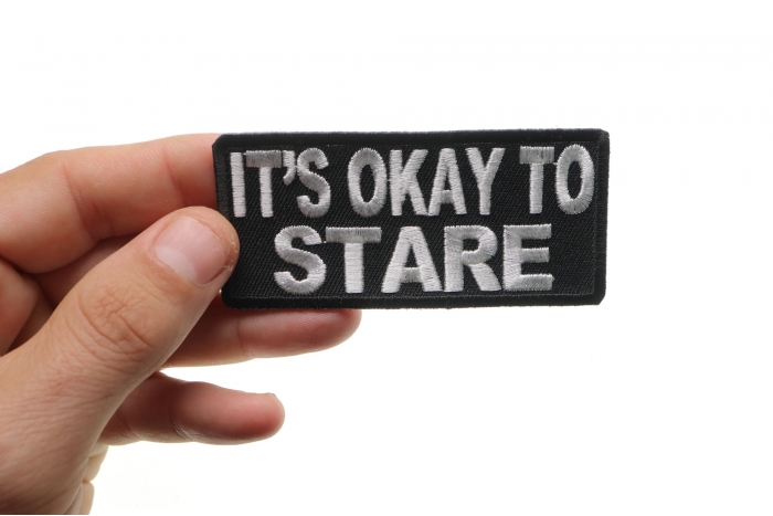 It's Okay To Stare Funny Iron on Patch shown on hand for size comparison
