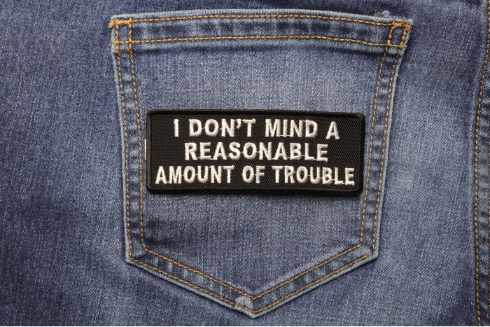 I Don't Mind A Reasonable Amount Of Trouble Naughty Iron on Patch shown on jeans