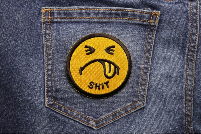 Shit Smiley Face Patch shown on jeans