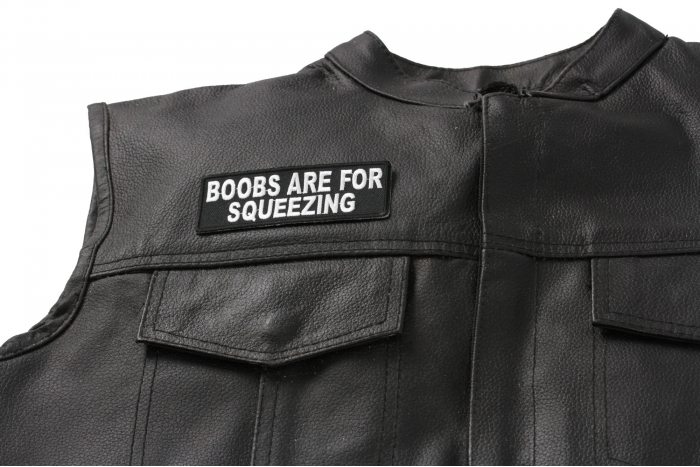 Boobs Are For Squeezing Fun Patch - 4x1.5 inch. Embroidered Iron on Patch shown on leather vest