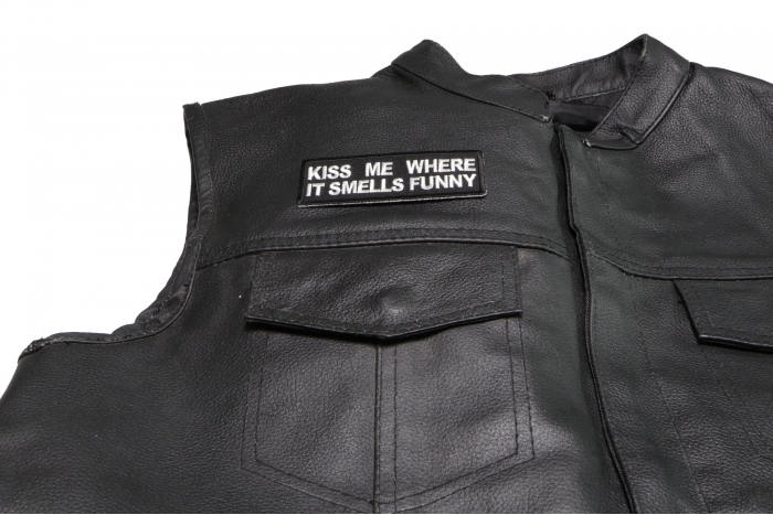 Kiss Me Where it Smells Funny Patch - 4x1.5 inch. Embroidered Iron on Patch shown on leather vest