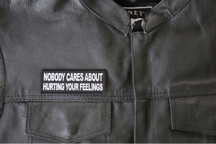Nobody Cares About Hurting Your Feelings Patch - 4x1.5 inch - Embroidered Iron on Patch shown on leather vest