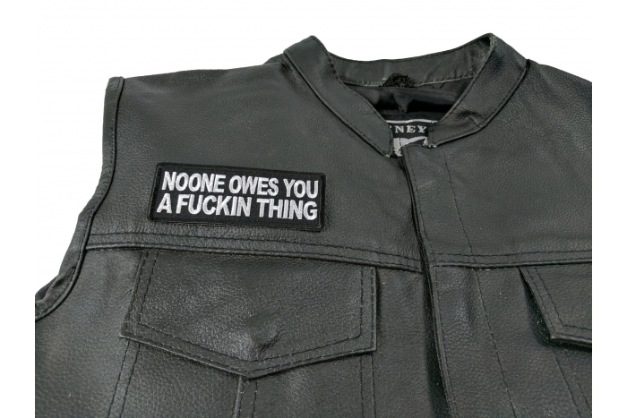 Noone Owes You a Fucking Thing Patch - by Ivamis Trading - 4x1.5 inch - Embroidered Iron on Patch shown on leather vest