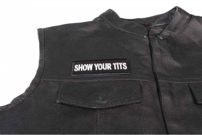 Show Your Tits Patch - 4x1.5 inch. Embroidered Iron on Patch shown on leather vest
