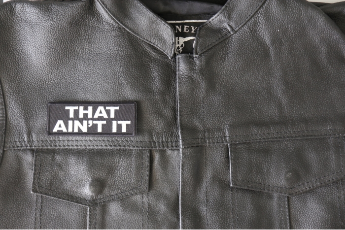 That Ain't It Patch - 4x1.5 inch - Embroidered Iron on Patch shown on leather vest