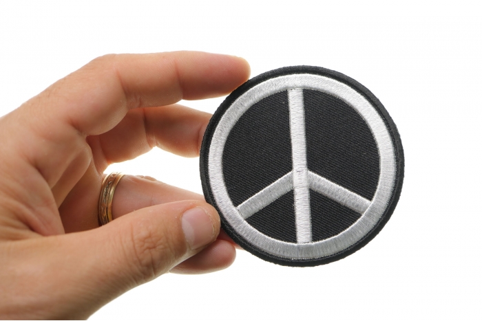 Black White Peace Sign Novelty Iron on Patch shown on hand for size comparison