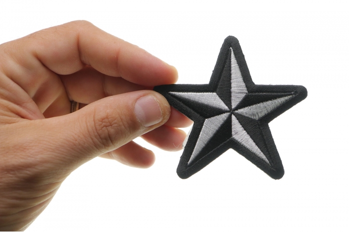 Black White Nautical Star Iron on Novelty Patch shown on hand for size comparison