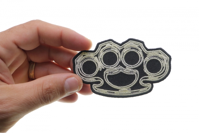 Brass Knuckles Iron on Novelty Patch shown on hand for size comparison