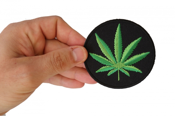 Cannabis Leaf Novelty Iron on Patch shown on hand for size comparison