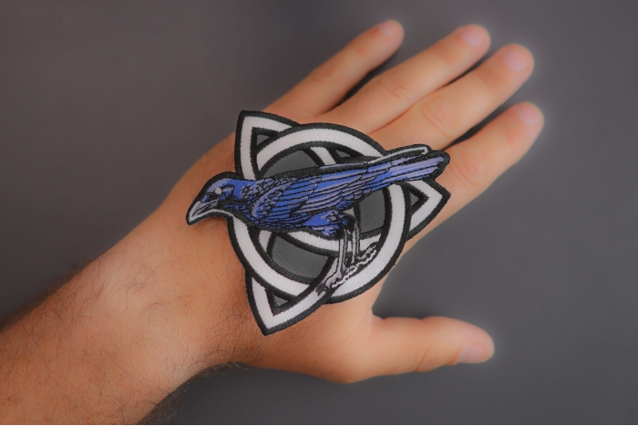 Celtic Crow Patch shown on hand for size comparison